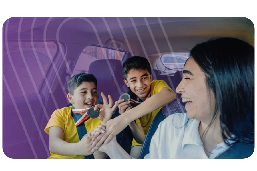 Adult driving a car, a teenager in the front seat, and a teenager in the back seat